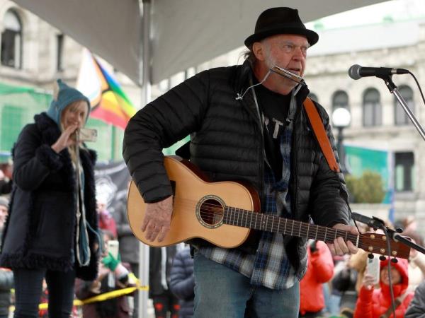 Rock legend Neil Young performs during a rally against the destruction of old growth forests on the front lawn of the legislature in Victoria, B.C., on Saturday, February 25, 2023.