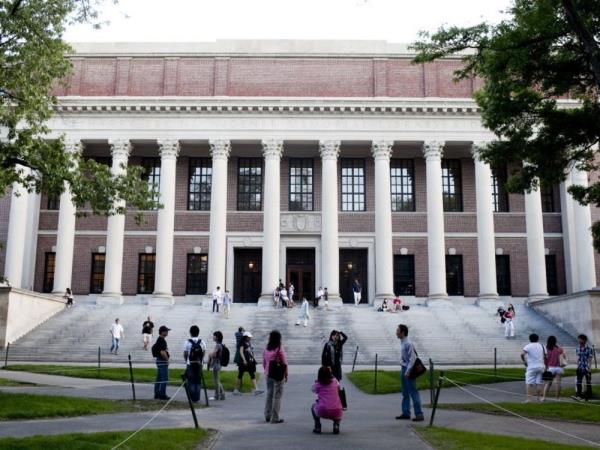 Tourists gather in front of the Harry Elkins Widener Library on the campus of Harvard University in Cambridge, Mass.