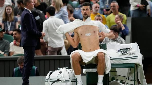 Serbia&#39;s Novak Djokovic changes his shirt during a change of ends break as he plays against Poland&#39;s Hubert Hurkacz in a men&#39;s singles match on day seven of the Wimbledon tennis champio<em></em>nships in London, Sunday, July 9, 2023. (AP Photo/Kirsty Wigglesworth)